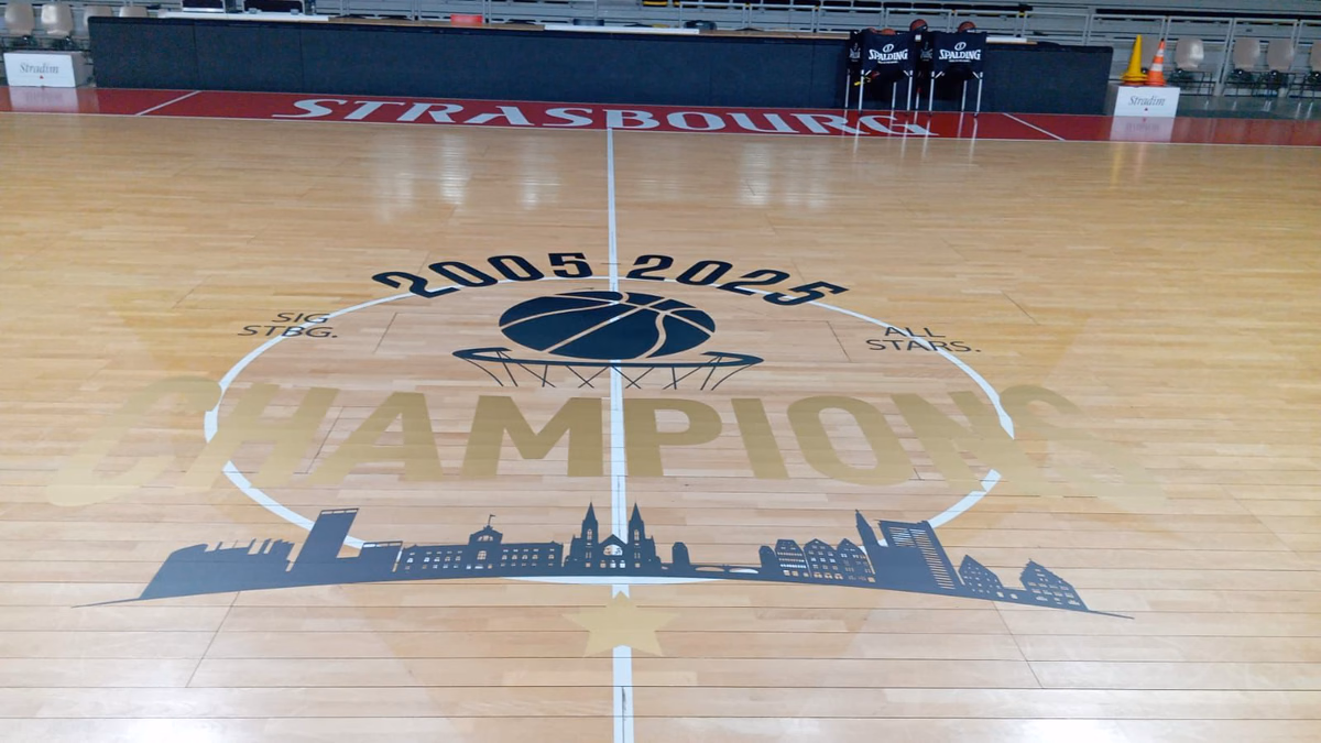 Vinilo de círculo central en una pista de baloncesto de parquet claro, vista amplia de la cancha
